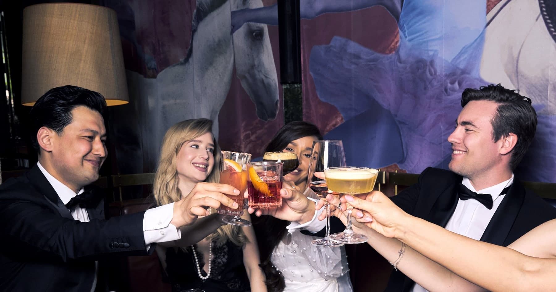 Fünf Gäste stoßen mit ihren Cocktails an